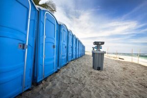 porta potties in line on the beach with hand washing station